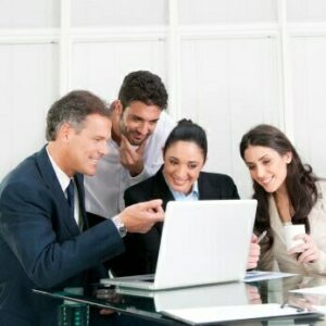 Team of office workers gathered around a laptop computer
